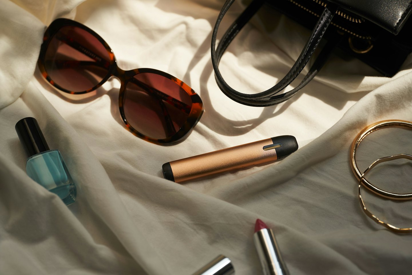 Women's accessories arranged on a beige fabric.
